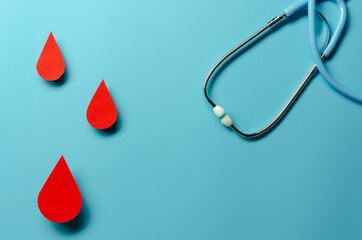 Fototapeta premium Blood drop symbol on blue background. Hemophilia day, blood donor day.