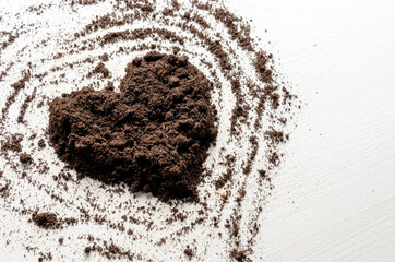 Heart shaped dry soil on white wooden background. Earth day