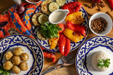 Grilled vegetables, boiled rice and baked potatoes in traditional Uzbek dishes.