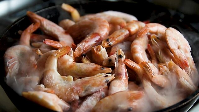 the prawns are heated up in frying pan there is steam