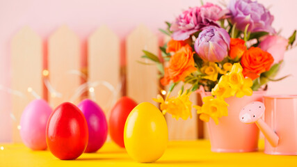 Easter colorful eggs on the background of spring flowers. Bright Easter concept. Copy space.
