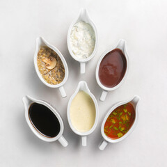 Set of several different sauces on a white marble table
