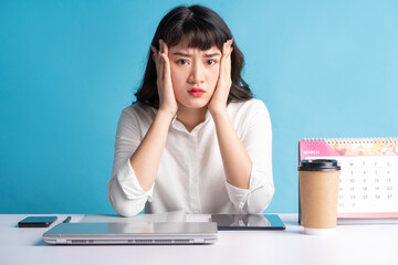 Fototapeta premium Young Asian buisness woman working on blue background