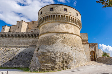 Fototapeta na wymiar View of the ancient Rocca di San Leo fortress on a sunny day and blue sky, Rimini, Italy