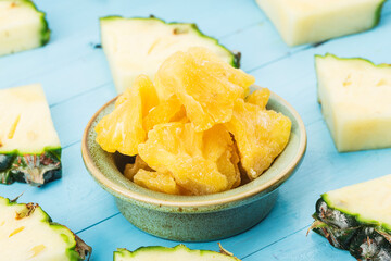 Dried pineapple in the bowl on wood background
