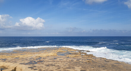 Obraz premium Waves crash against a rocky shore. Sliema, Malta