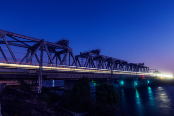High-speed rail travels on the bridge at night