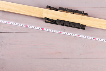 tools for marking and sawing boards on a workbench.
gray workbench. miter box with a board. 