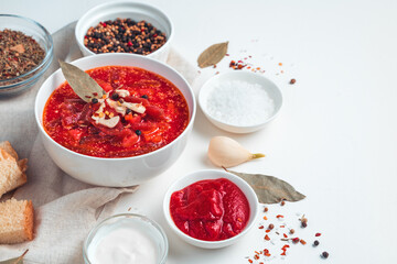 Delicious borscht with garlic and bay leaf on a white background.