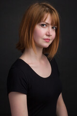 Fototapeta premium studio portrait of a young brown-haired woman, on a black background