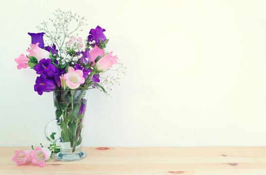 spring bouquet of white and pink bell flowers over wooden table