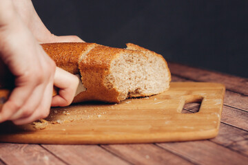 slicing a loaf on a wooden cutting board freshness