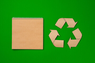 Paper recycling concept on green background top view