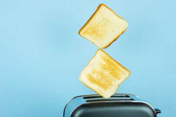 Toaster with bread slices on color background