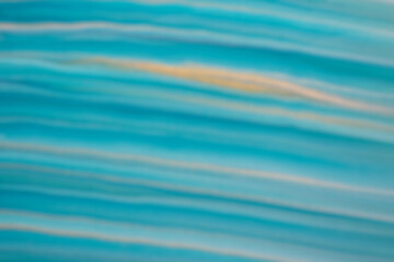 Blurred blue and golden background with turquoise lines. Defocused art