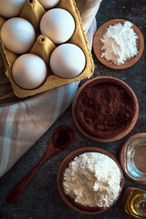close-up of ingredients for chocolate cake, flour, baking cocoa, eggs, baking powder, oil, vanilla essence, ideal for recipes.