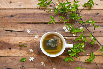 herbal healthy drinks hot tea with flowers, leaf arrangement flat lay style on background wooden