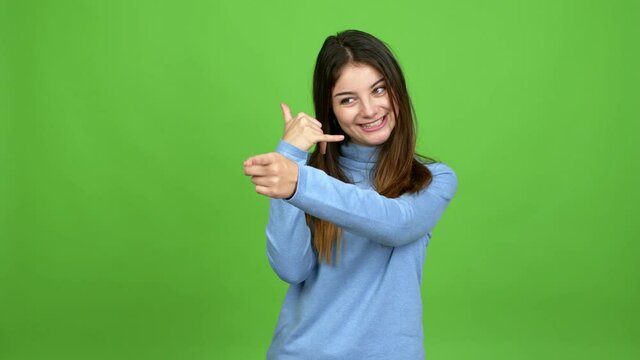 Young caucasian woman making phone gesture and speaking with someone. Call me back sign over isolated background. Green screen chroma key