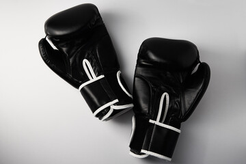 Pair of black boxing gloves on white background, closeup