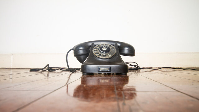 vintage black phone on a wooden floor 