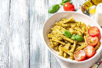 vegan pasta with homemade pesto sauce of basil, pine nuts and olive oil with cherry tomatoes. comfort food.