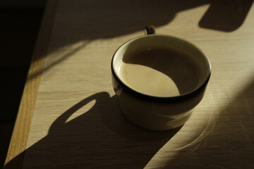 Coffee with milk on a table with beautiful light contrasts