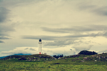Retro-style photo of Cape Egmont Lighthouse with Mount Taranaki in the background. Gloomy winter day in Taranaki, New Zealand