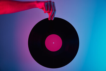 Hand hold retro vinyl disc with neon background