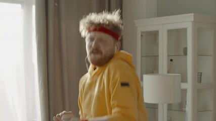 CU ZOOM Portrait of funny Caucasian man dancing to the music during workout at home in the morning. Motivation, self confidence concept