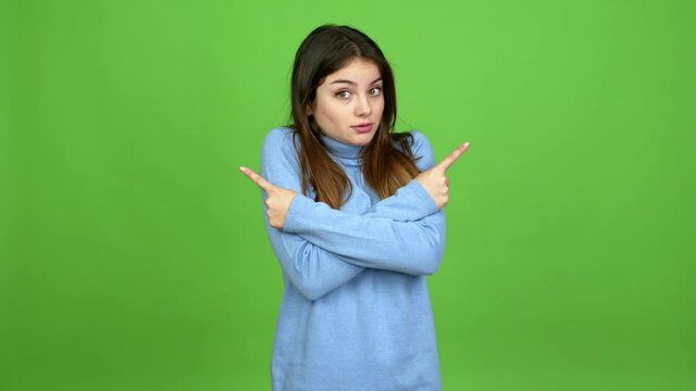 Young caucasian woman pointing to the laterals having doubts over isolated background. Green screen chroma key