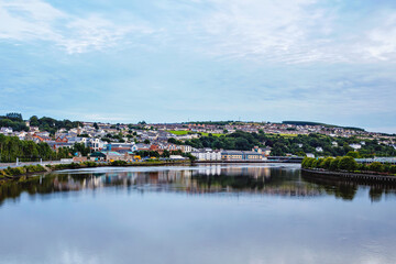 Fototapeta na wymiar Derry, North Ireland. Aerial view of Derry Londonderry city center in Northern Ireland, UK. Sunny day with cloudy sky, city walls and historical buildings