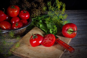 A group of freshly washed tomatoes and parsley is lying on a table of old boards.Dark background. Tomatoes and parsley are ingredients of vegan, Keto and Paleo diets. Detox,