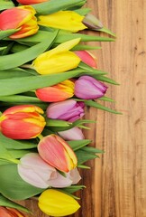 Spring tulips bouquet on wooden background.