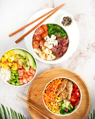Asian trendy poke bowls with salmon, tuna, heura soy protein vegan chicken, variety vegetables,...