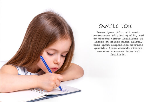 Little girl sits at the table  and draws in a notebook, isolated
