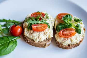 Fototapeta na wymiar egg cheese ham dip, spread on open finger food sandwich with salad, tomato vegetables 