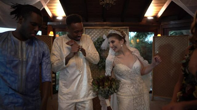 Bridal couple dancing with guests at wedding party