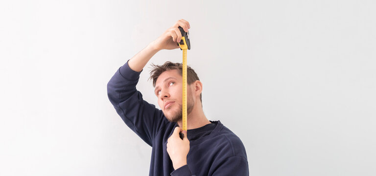 Simple Adult Teenager Male Person With A Roll Tape Measure The Height Against The Wall