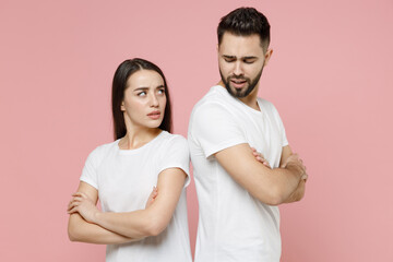 Young irritated dissatisfied couple two friends man woman in white basic t-shirt quarrel swearing have problem stress need family psychologist isolated on pastel pink color background studio portrait