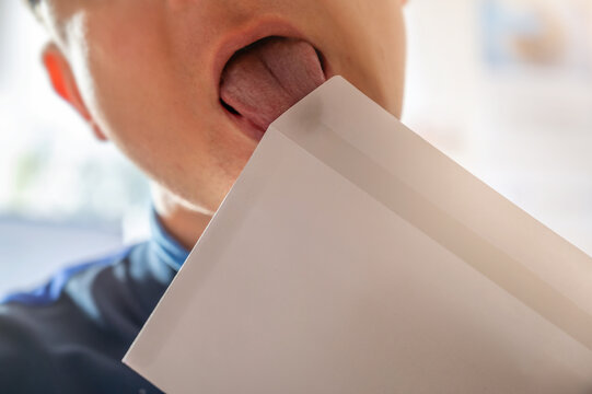Anlecken eines Briefes zum Zukleben des Umschlags als Symbol f&uuml;r die Verbreitung von Krankheitserregern