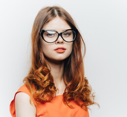 Fototapeta premium red-haired woman in orange sundress makeup hairstyle glasses