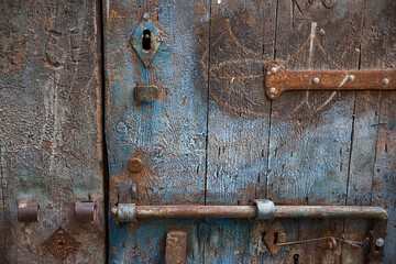 Old, distressed wooden door, Sotoportego E Corte De Ca' Mariani, Santa Croce, Venice, Italy: bolt, lock and hinge