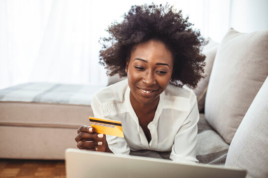 Picture showing pretty woman shopping online with credit card. Woman holding credit card and using laptop. Online shopping concept. Shot of an attractive young woman making payments online