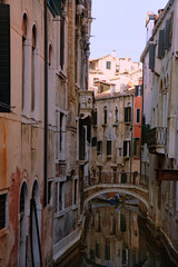 Fototapeta na wymiar A shady Venetian backwater and typical Venetian bridge: Rio della Madoneta, San Polo, Venice, Italy