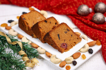 Indian Christmas celebration homemade Christmas plum cake cut into pieces for serving India Kerala Sri Lanka Fruitcake made of dried fruit, nuts, spices , rum for New Year party, Easter, Christmas Eve