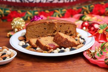 Fototapeta na wymiar Indian Christmas celebration homemade Christmas plum cake cut into pieces for serving India Kerala Sri Lanka Fruitcake made of dried fruit, nuts, spices , rum for New Year party, Easter, Christmas Eve