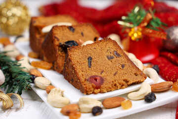 Indian Christmas celebration homemade Christmas plum cake cut into pieces for serving India Kerala Sri Lanka Fruitcake made of dried fruit, nuts, spices , rum for New Year party, Easter, Christmas Eve