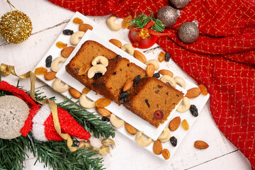 Indian Christmas celebration homemade Christmas plum cake cut into pieces for serving India Kerala Sri Lanka Fruitcake made of dried fruit, nuts, spices , rum for New Year party, Easter, Christmas Eve