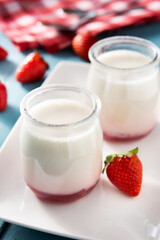 Panna cotta dessert with strawberry on blue wooden table