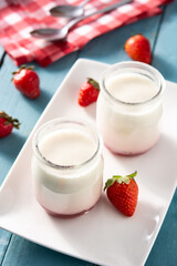 Panna cotta dessert with strawberry on blue wooden table